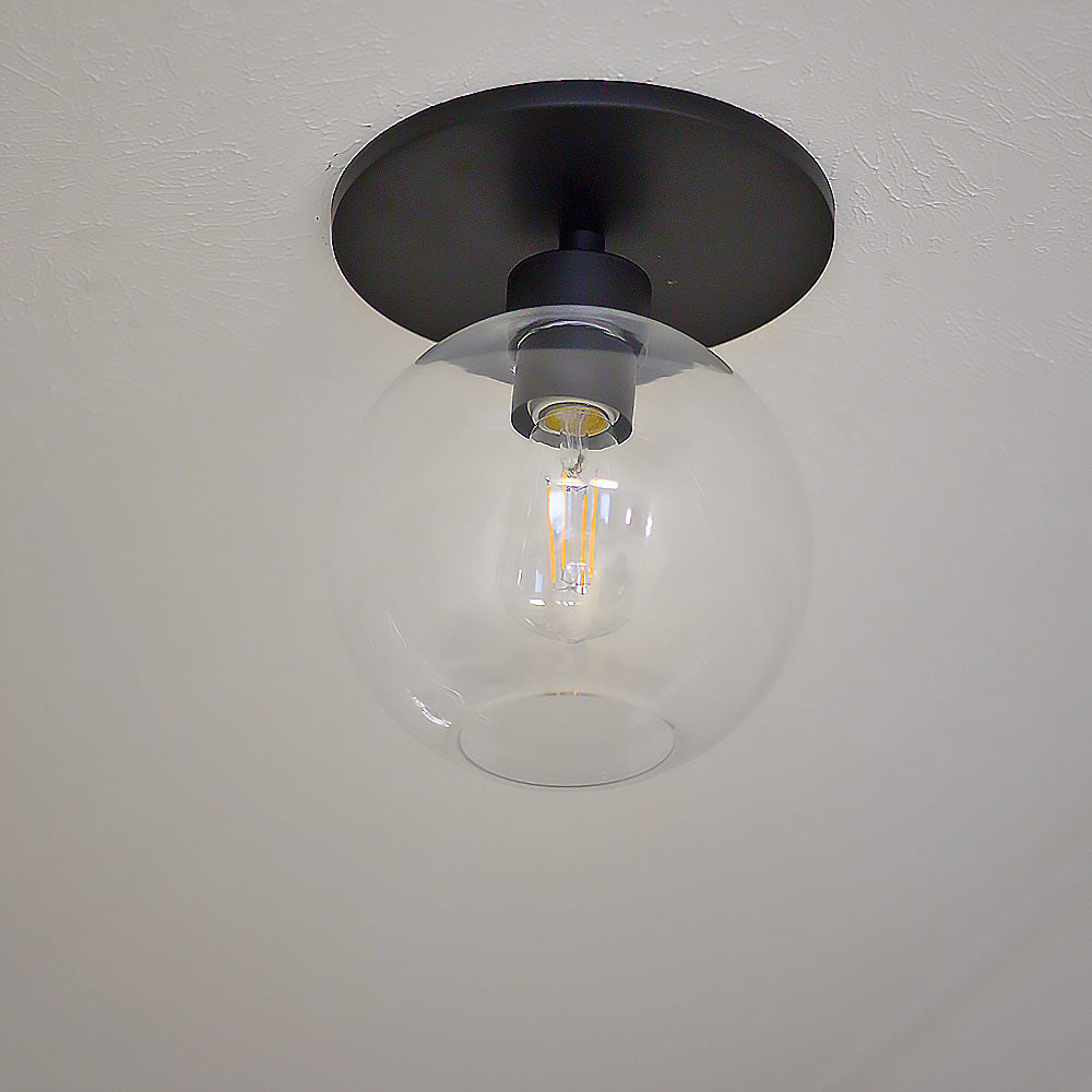 Matte Black Clear Globe Instant Semi Flush 6" Recessed Conversion Kit installed in the ceiling